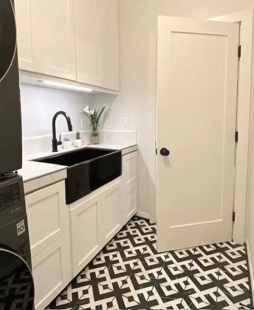 Photo of an modern laundry room with high-contrast black and white motif and patterned tiles