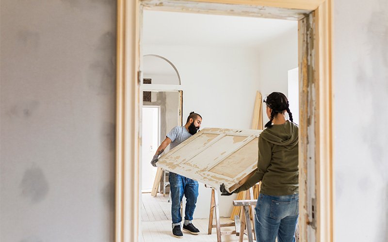 Photo of contractors carrying a door to be installed during a home renovation